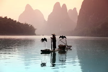 Photo sur Plexiglas Guilin YANGSHUO - JUNE 18: Chinese man fishing with cormorants birds in