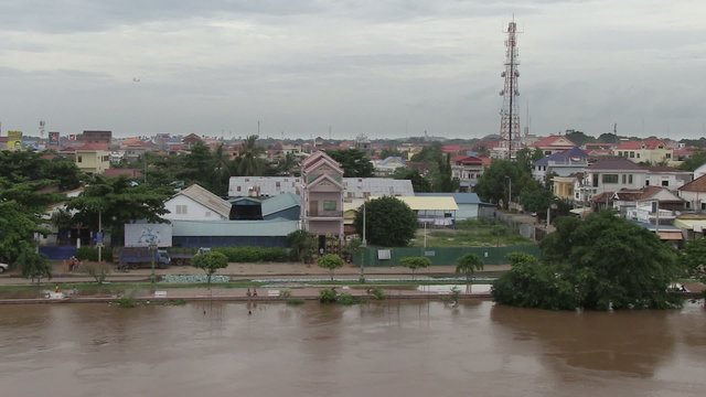 Riverside town protected from the rise in the water level with sand bags placed along the river's edge (Flooded river )	