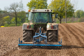 Traktor mit Kreiselegge bei der Feldbearbeitung  - 1524