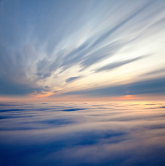 Flight between clouds during sunrise