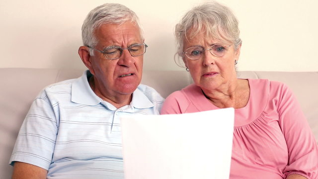 Worried Senior Couple Reading A Document