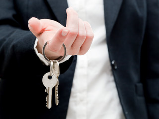 A real estate agent holding keys to a new house in her hands.