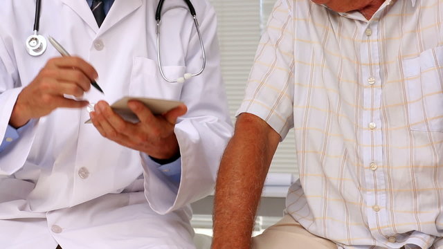 Doctor shaking hands with his patient and giving his a prescript
