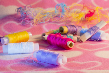 Colored thread and needle on fabric