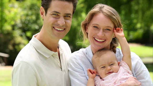 Happy parents with their baby girl in the park