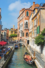 Naklejka premium Scenic view of streets in Venice with gondola middle of the chan