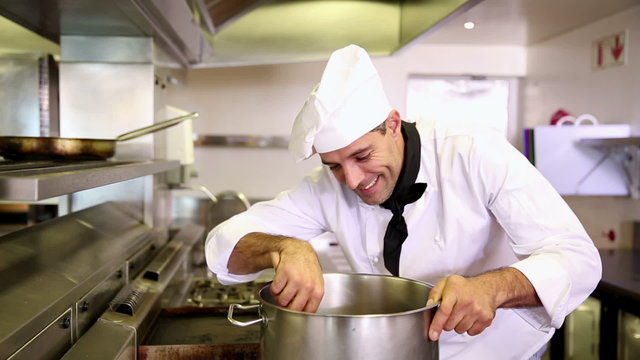 Handsome chef stirring a large pot