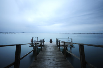 Lonely girl on a pier