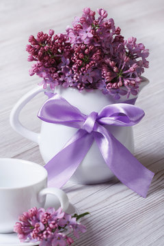 serving breakfast: a cup and a jug decorated with lilac flowers