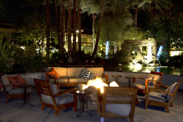 Patio furniture pool side lit up at night