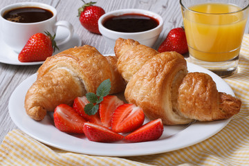 breakfast: croissants with strawberries and coffee, juice
