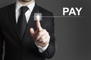 businessman pressing virtual button pay