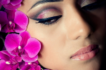Closeup shot of a beautiful woman's face with orchids