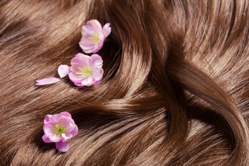Obraz na płótnie Canvas Piękne zdrowe lśniące włosy z kwiatami sakura