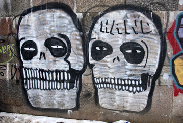 two grafitti skull on city wall