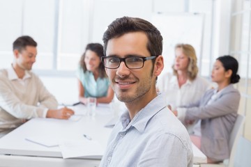 Fototapeta premium Casual businessman smiling at camera during meeting