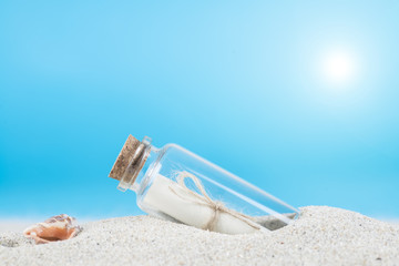 Mensaje en una botella de cristal en la arena de la playa