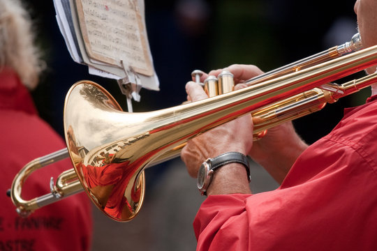Mains jouant du trombone à coulisse lors d'un défilé de fanfare