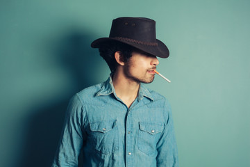 Young cowboy smoking cigarette