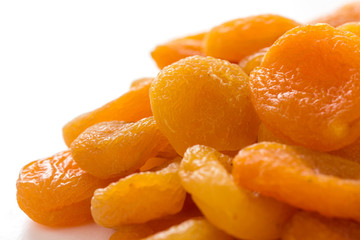 Dried apricots on white surface with shallow depth of field