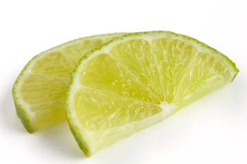 Thinly cut lime slices on white surface © Moving Moment