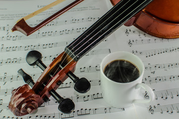 Naklejka premium Closeup photo of violin and steamy cup of coffee