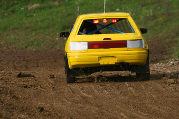 Plakat Yellow car on track going fast and throwing dirt in the air