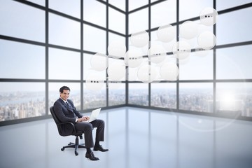 Composite image of young businessman sitting on an armchair work