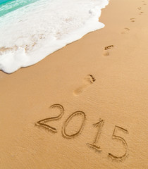 2015 and footprints on sand beach