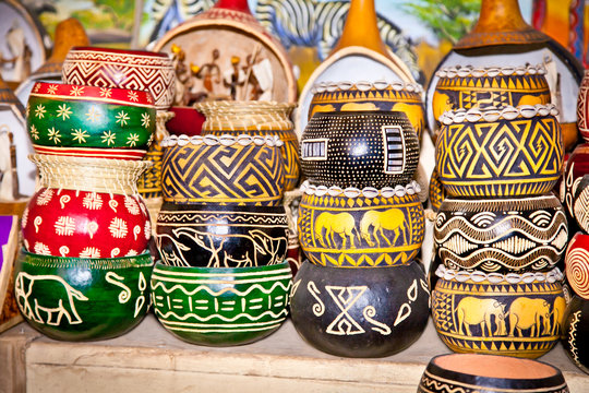 Colorfully painted wooden pots in market,  Africa.