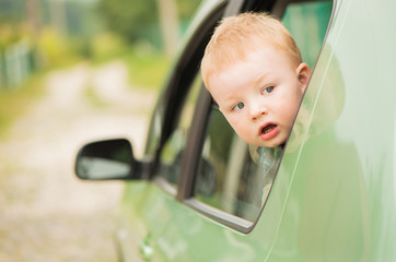 cute kid head outside green auto window