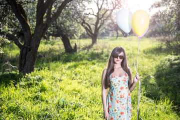 Naklejka na ściany i meble Girl with balloons in the apple orchard
