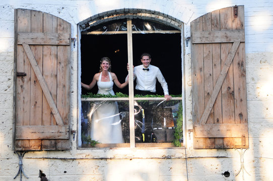 Brautpaar schaut aus einem Tor
