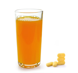 Full glass of orange juice and Vitamin C pills  isolated on whit