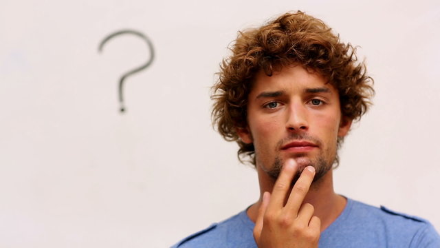 Confused student standing in front of whiteboard with question m