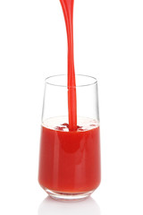 Juice pouring into glass isolated on white