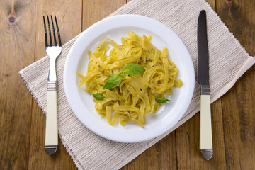 Delicious pasta with pesto on plate on table close-up
