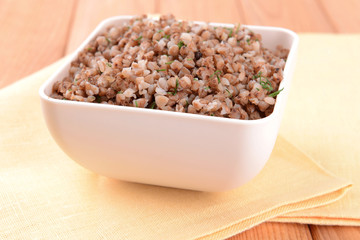 Boiled buckwheat in bowl on table close-up