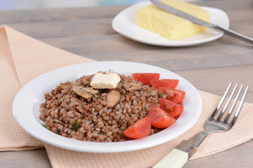Boiled buckwheat on plate on table close-up