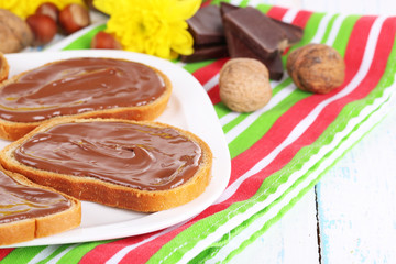 Bread with sweet chocolate hazelnut spread on plate on table