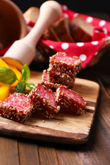 Composition of knife,    sliced salami sausage with sesame,