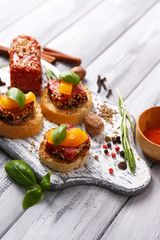 Composition of tasty sandwiches with salami sausage, basil leaf