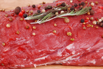 Raw beef meat with spices on wooden background