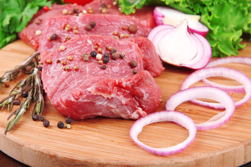 Raw beef meat with vegetables on table close up