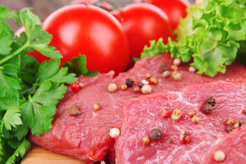 Raw beef meat with vegetables on table close up