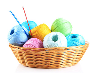 Colorful yarn for knitting in wicker basket and crochet hook,