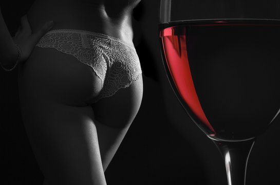 Beautiful silhouette of a female body and a glass of red wine