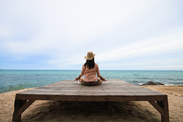 woman practices yoga on beach, meditation and relaxation