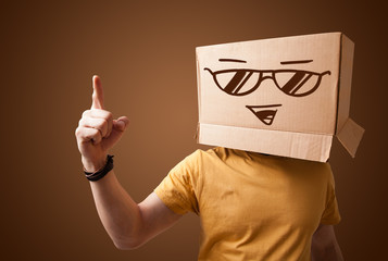 Young man gesturing with a cardboard box on his head with smiley