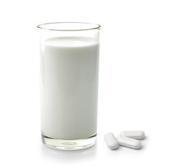 pill and glass of milk isolated on white background